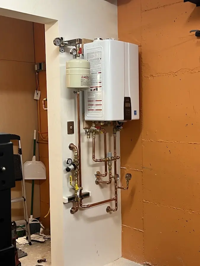 Plumbing technician inspecting water heater connections in Lewistown